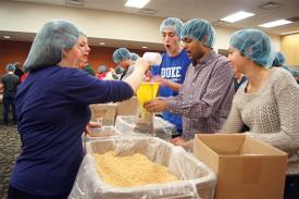 Students and community members volunteer during a past MLK Meal Packaging Event.