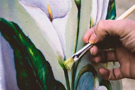 An artist paints a picture of a flower.