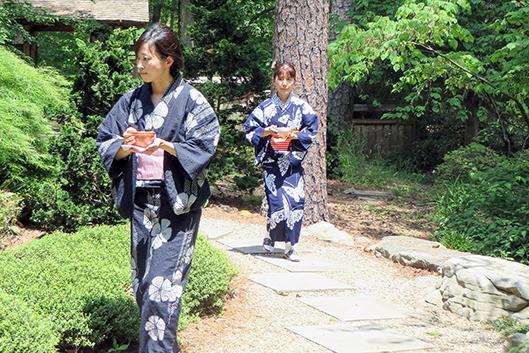 Japanese tea practitioners carrying bowls of tea. Japanese tea practitioners carrying bowls of tea.