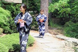 Japanese tea practitioners carrying bowls of tea.