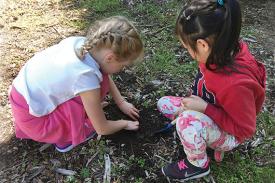 Two children dig into the soil.