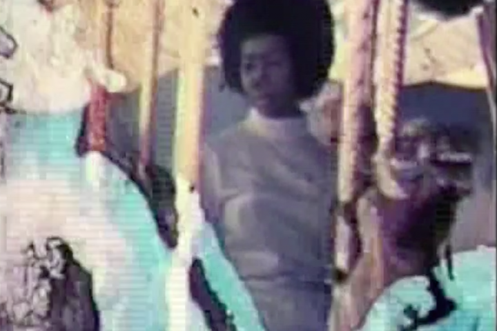 Still from an experimental video by Tamika Galanis in &quot;One Hurricane Season.&quot; A young black woman rides a carousel.