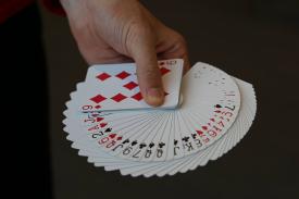 Hand holding playing cards showing all suites