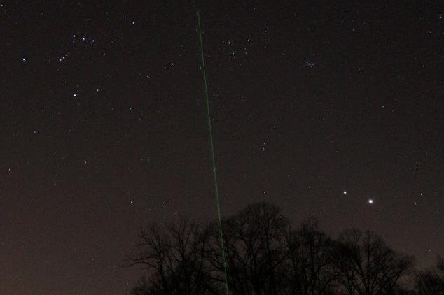 Image of laser pointer with spring stars over observatory