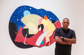 Artist Juan Logan poses with his work at the Nasher