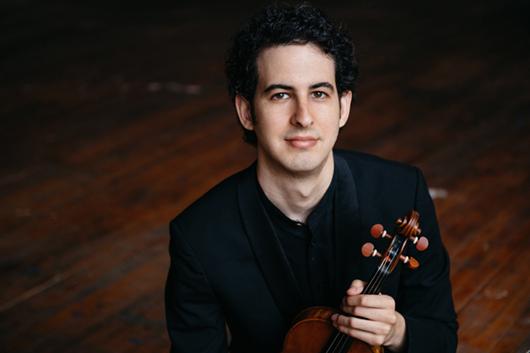 Violinist Itamar Zorman holding his violin