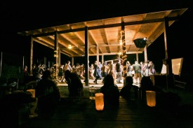 people dancing and holding hands at night under pavilion