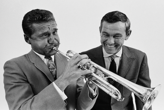 Photo of Doc Severinsen playing the trumpet, pictured with Johnny Carson.