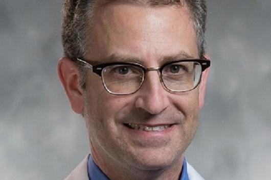 Dr. Bradley Goldstein: White man, grey hair, glasses, smiling