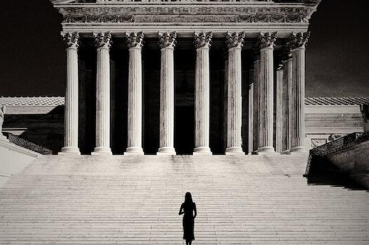 silhouette of woman walking toward Supreme Court building