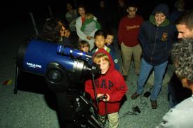 A boy operating telescope at Open House