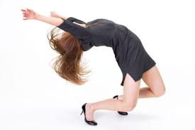 Woman throwing her body backwards modern dancing in professional work clothes.