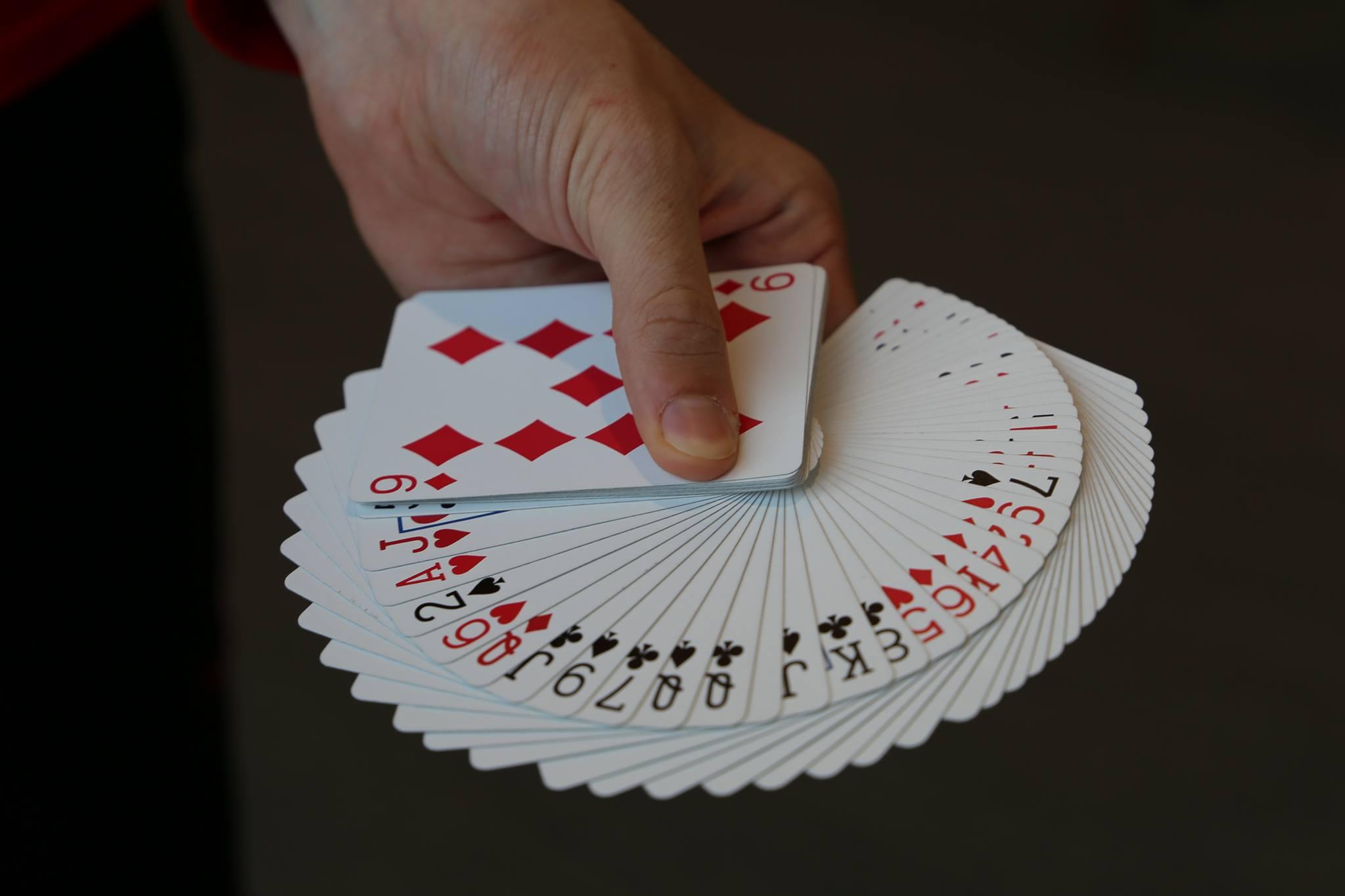 Hand holding playing cards showing all suites Hand holding playing cards showing all suites