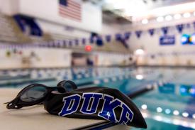 Duke swim cap and goggles on starting platform at edge of pool