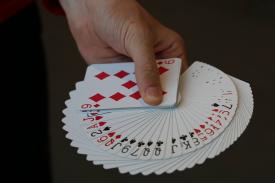 Hand holding a deck of cards facing up Hand holding a deck of cards facing up