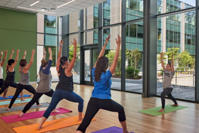 Participants standing in forward lunges, arm stretched up towards the ceiling Participants standing in forward lunges, arm stretched up towards the ceiling
