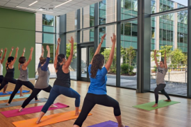 Participants standing in forward lunges, arm stretched up towards the ceiling Participants standing in forward lunges, arm stretched up towards the ceiling
