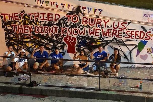 Latinx students in front of a mural at the East Campus bridge