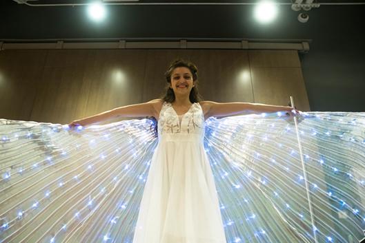 Madeleine Collier wearing a white dress with light-up wings by Ryan Harrison