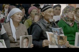 A group of Uyghur people hold images of family members