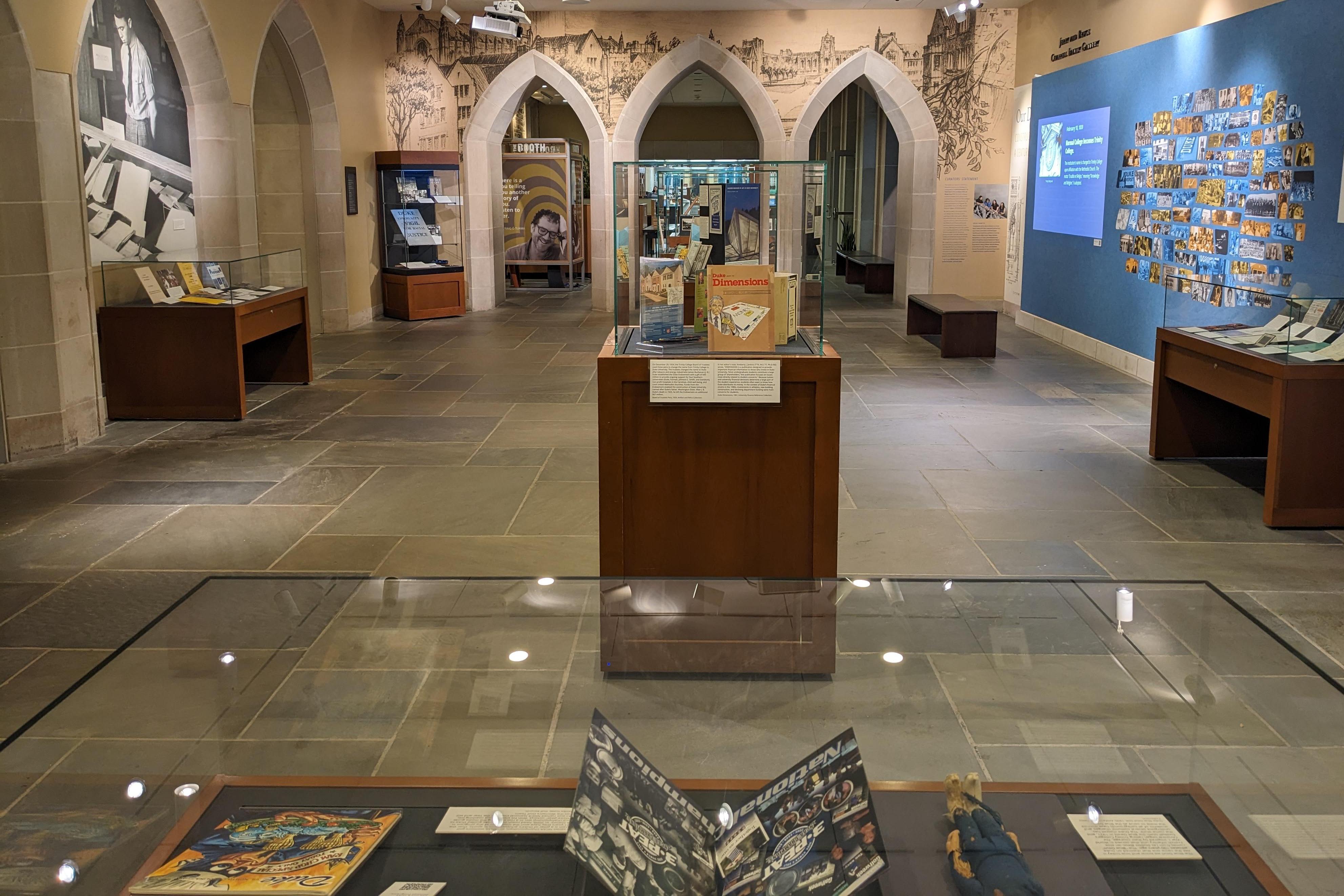 Exhibit gallery with cases and graphics on wall; front case shows Duke blue devil