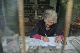 A person writing a letter at a table