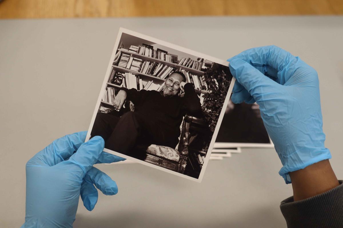 Photo of archivist holding a photo of Stuart Hall Photo of archivist holding a photo of Stuart Hall